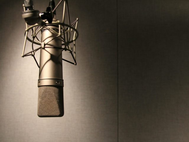 A studio microphone on a dark table