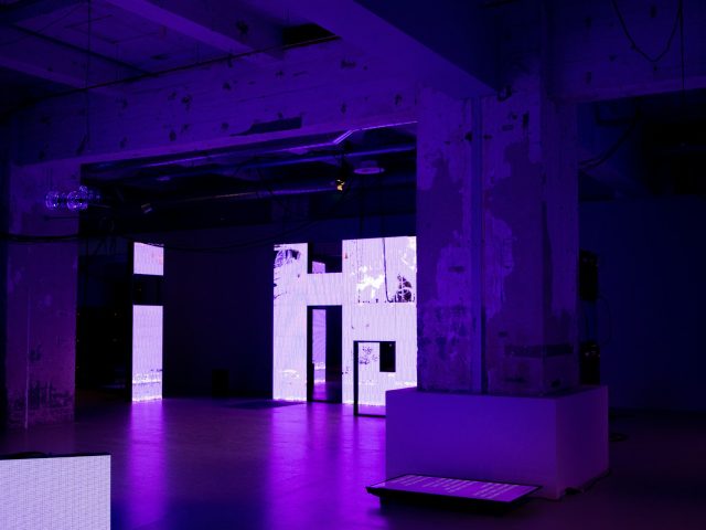 An empty room washed in purple LED light