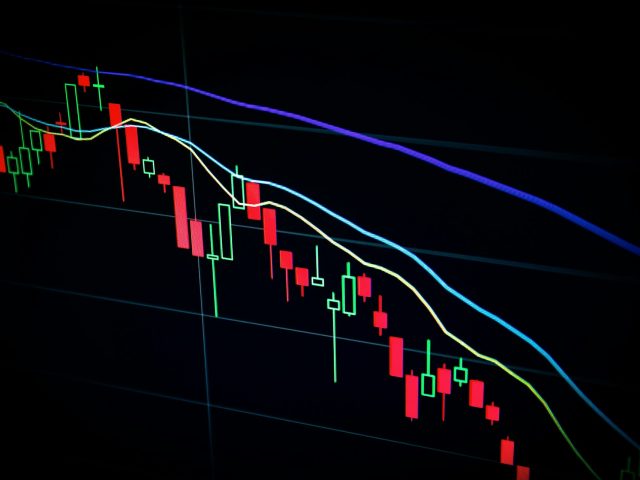 A candlestick trading chart on a dark screen