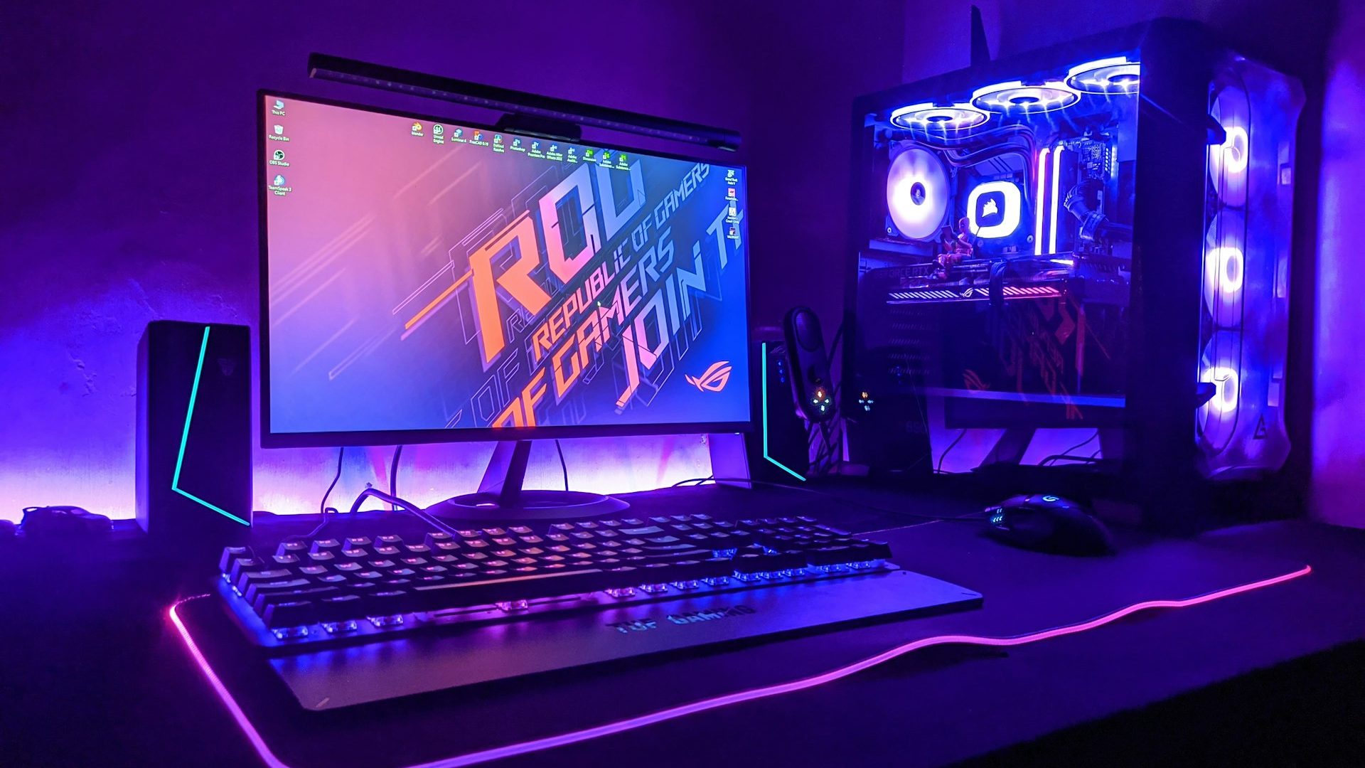 A gaming desk setup lit in purple