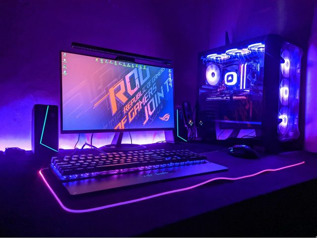 A gaming desk setup lit in purple