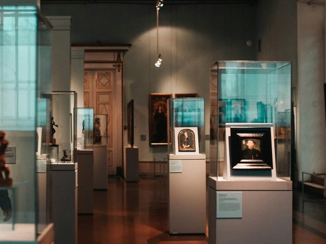 A museum room lined with glass display cases
