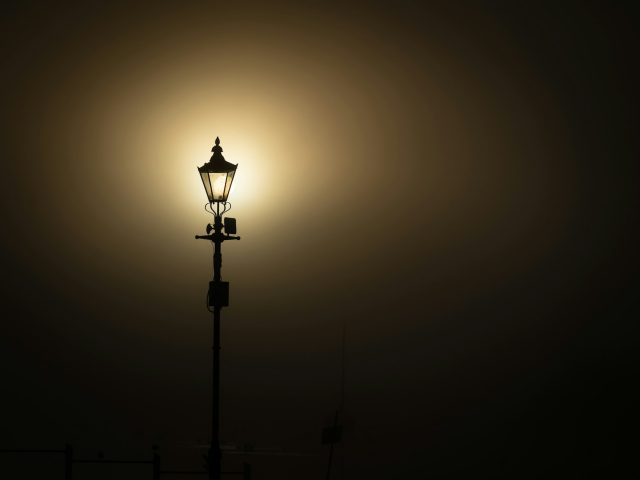 A single lamp glowing in a dark room