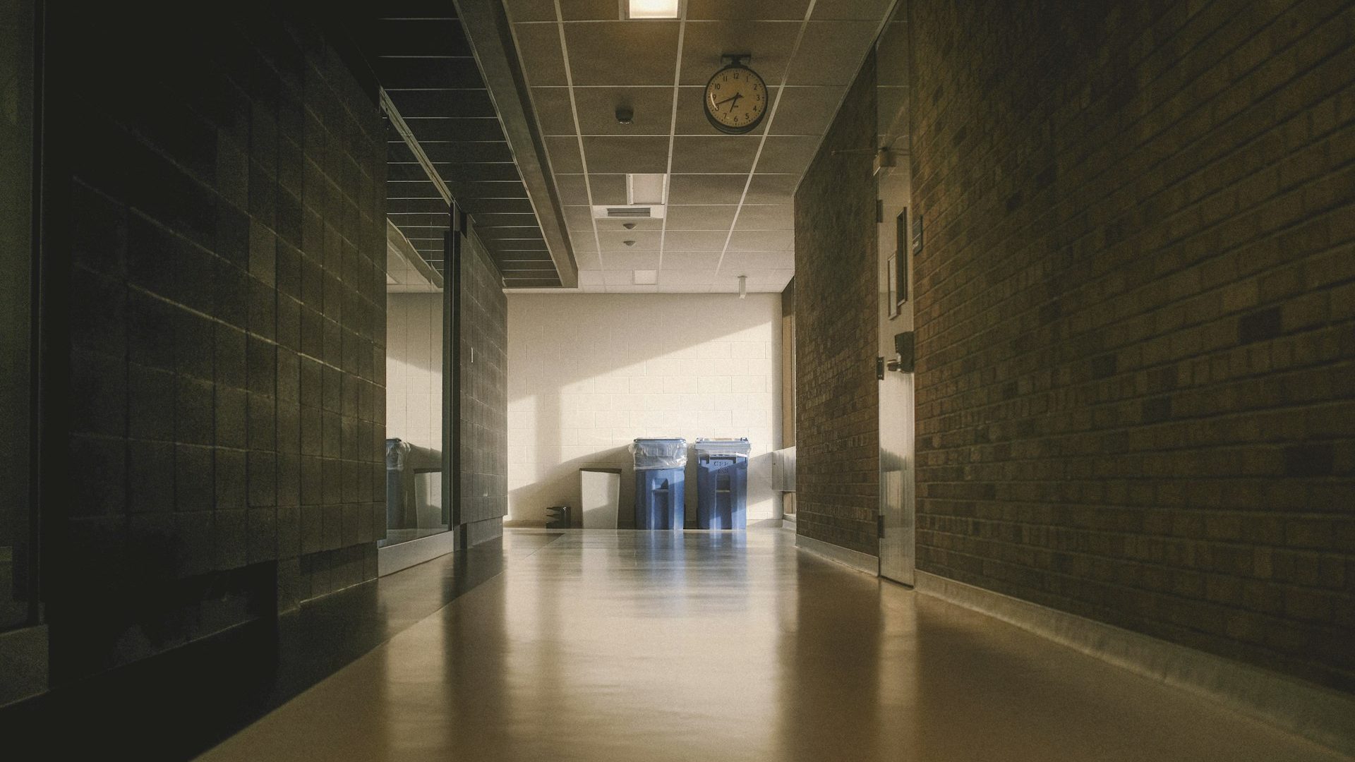 A long brightly lit hallway with brick walls
