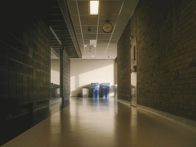 A long brightly lit hallway with brick walls