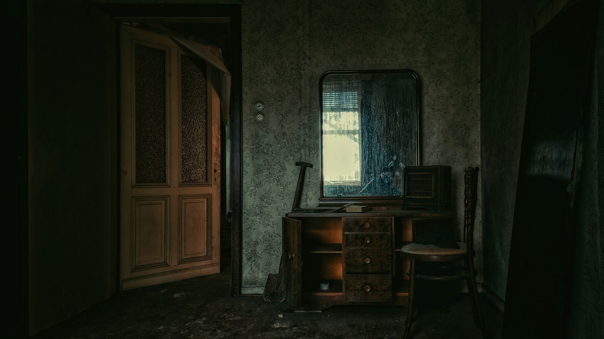 An abandoned room with a wooden door and desk