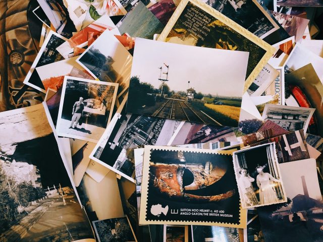 A scattered pile of old photographs and postcards