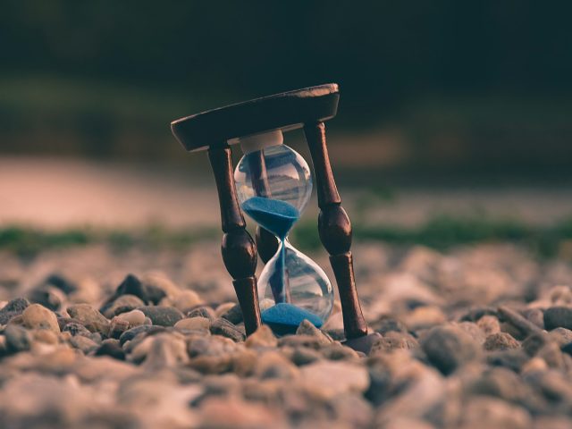 An hourglass resting on stones