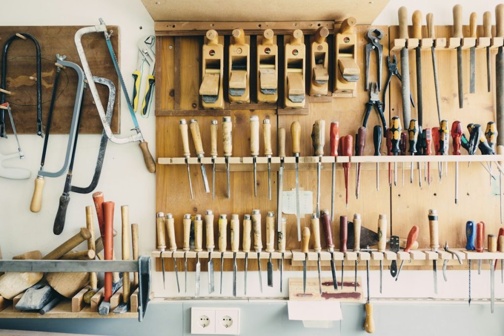 Assorted hand tools arranged in a wooden rack