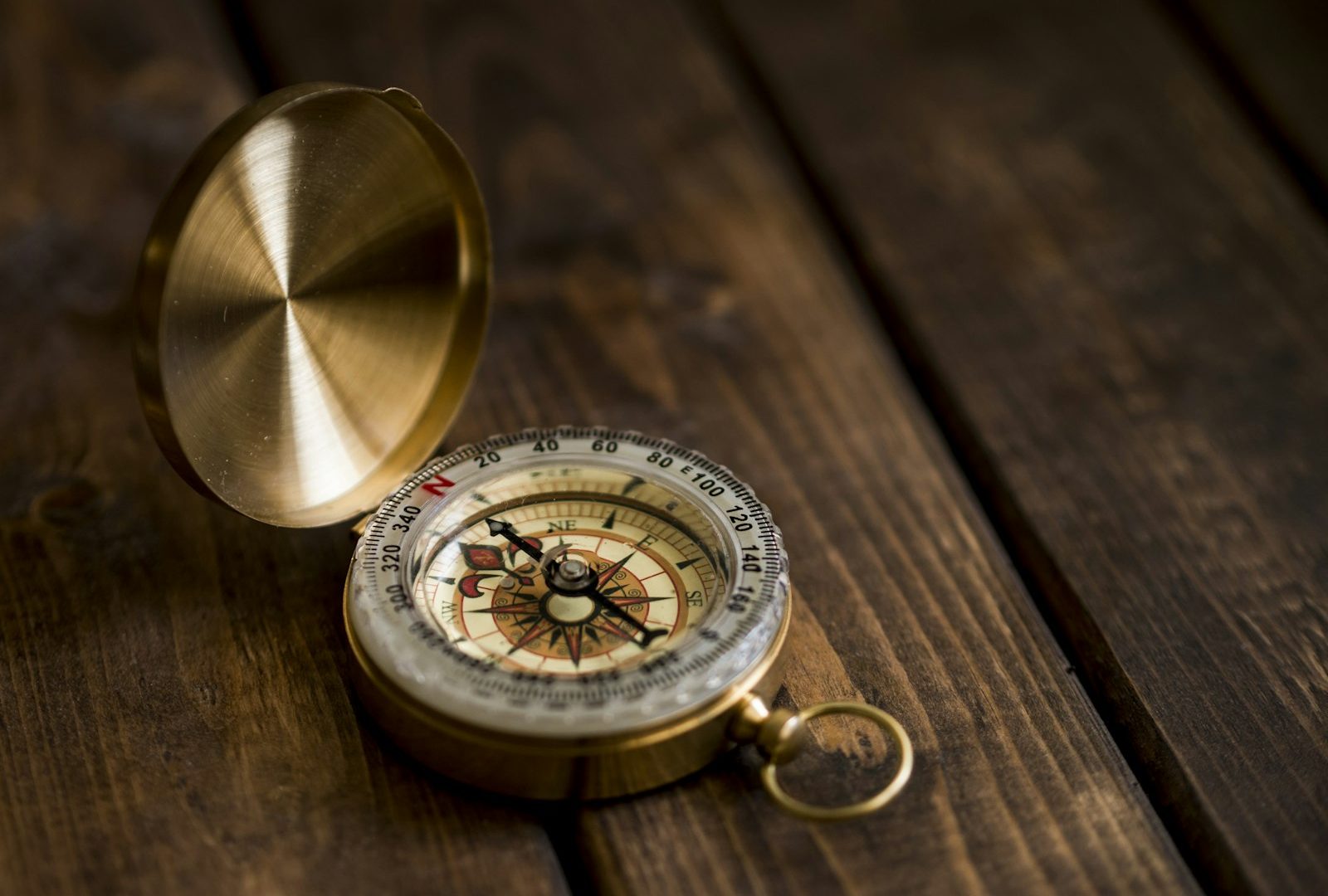A brass compass resting on a surface, shallow focus