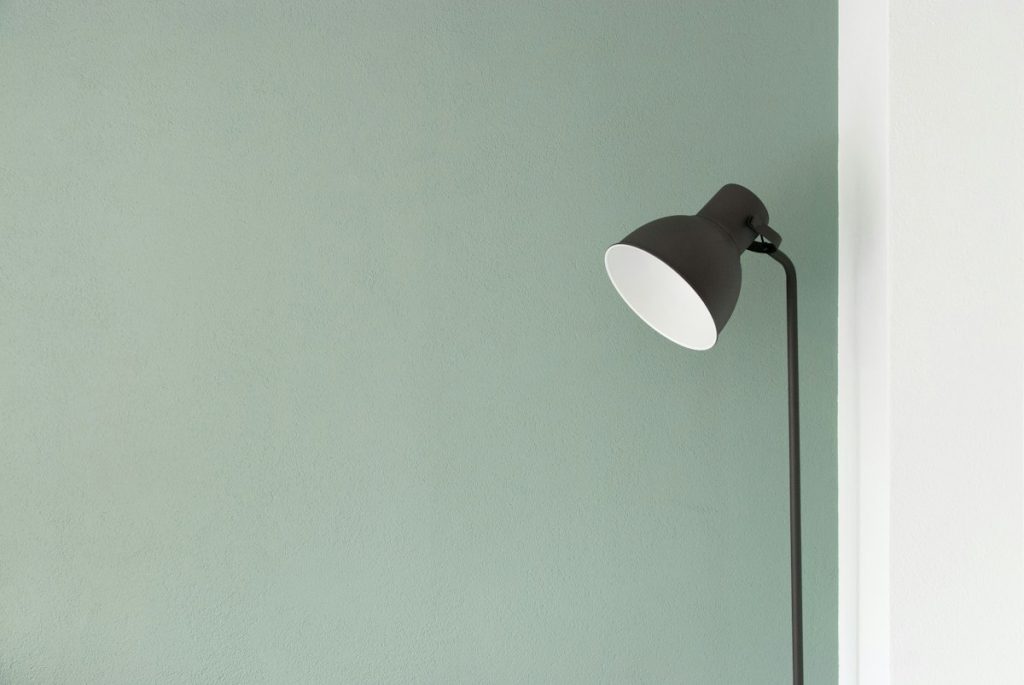 A floor lamp standing in the corner of an empty room