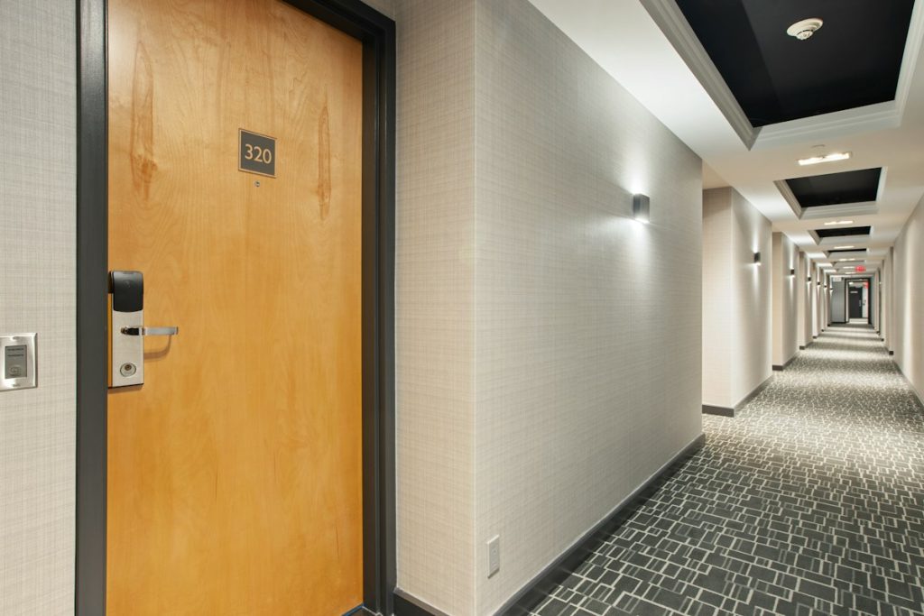 A wooden door set in a tiled corridor