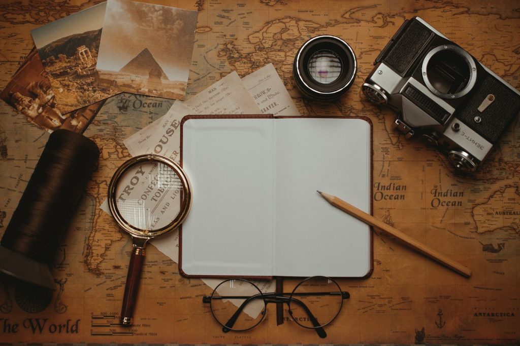 An open notebook with a magnifying glass and pen resting on it