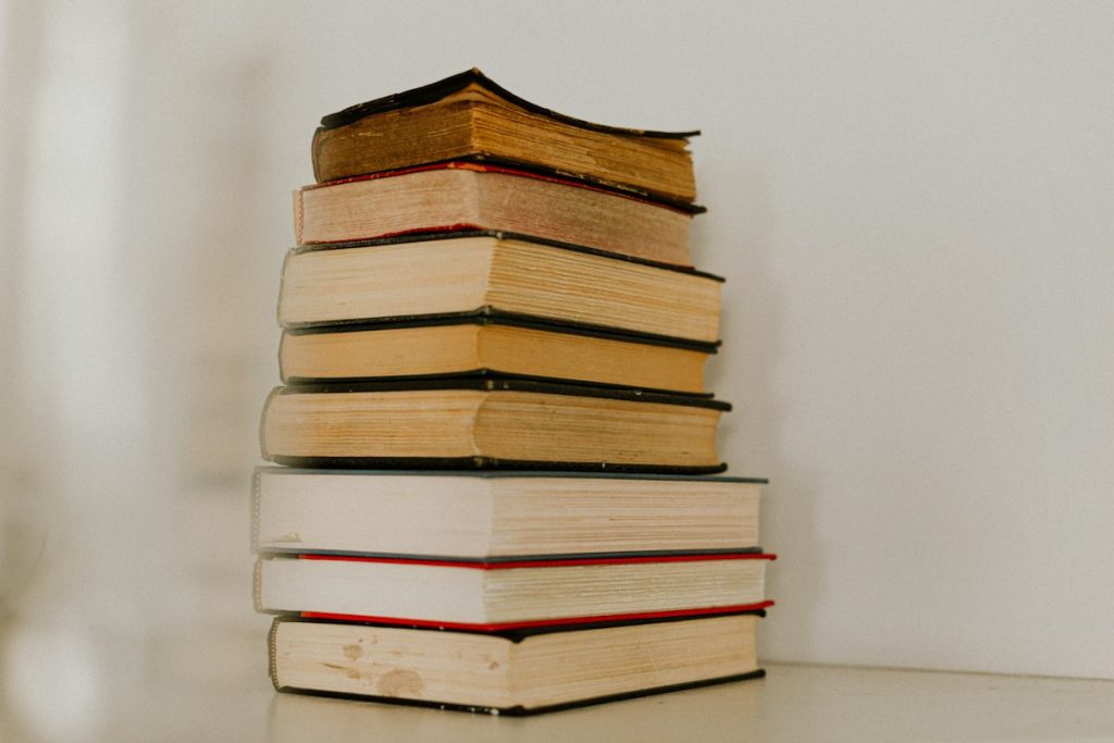 A neat stack of books on a pale surface