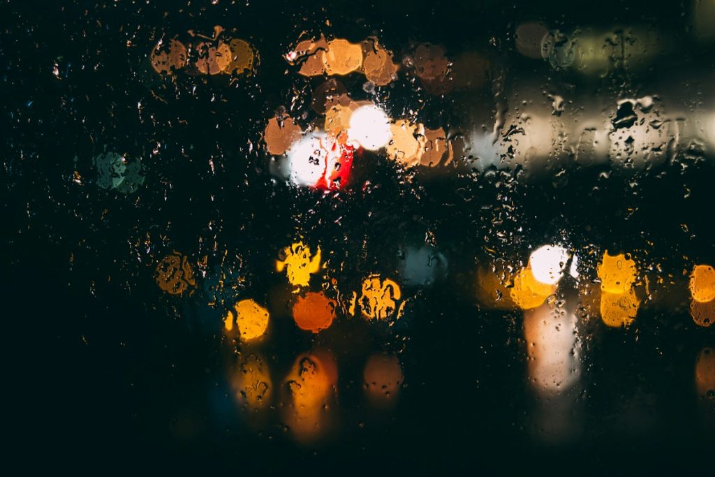 Rain running down a window at night