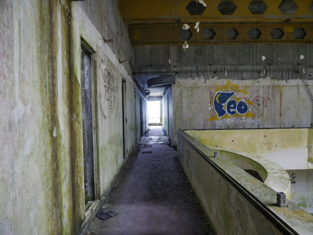 A decaying concrete hallway in an abandoned building