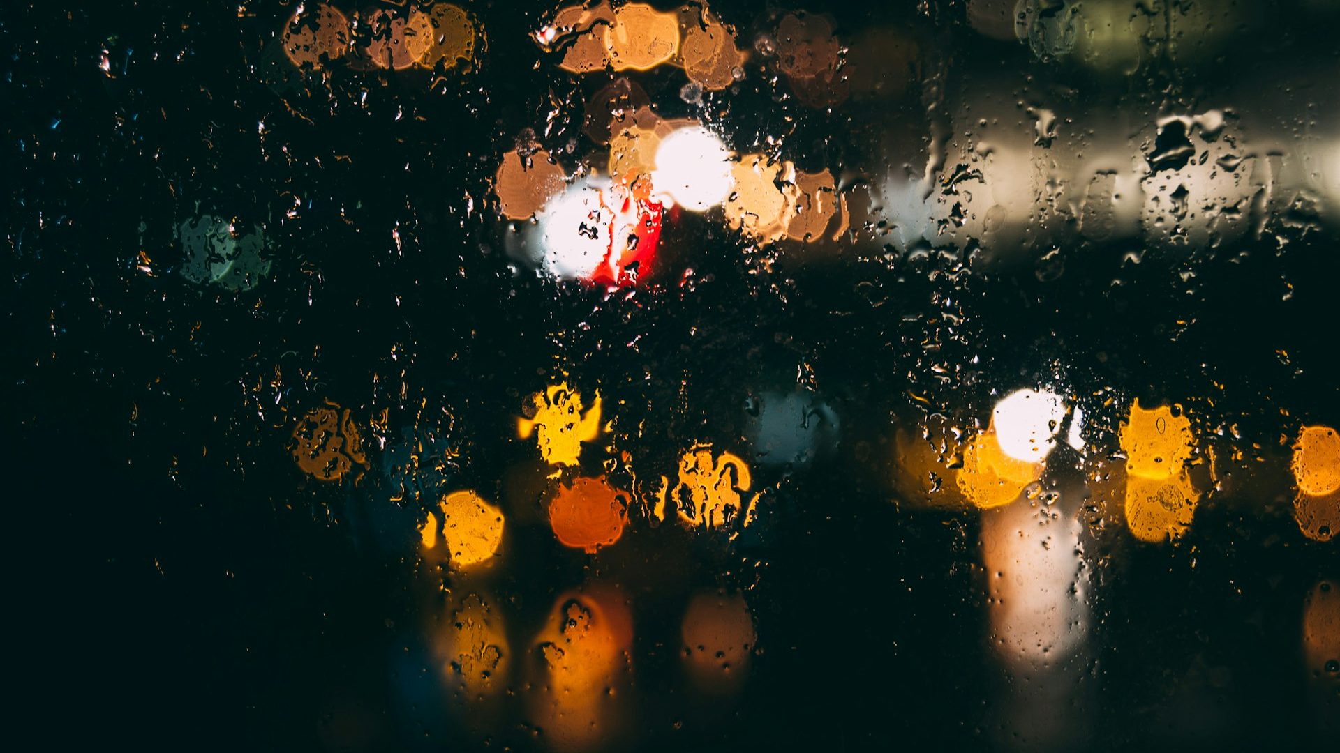 A rain-covered window at night