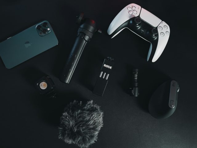 Assorted small electronics laid out on a black desk