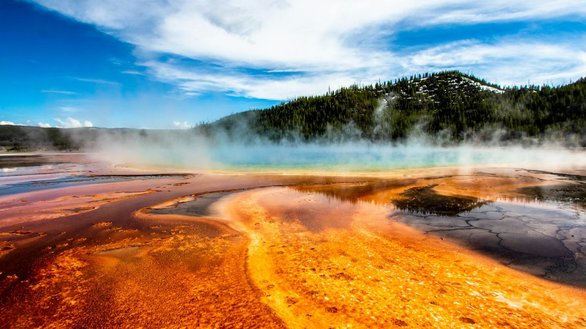 A geyser erupting in a mountain landscape