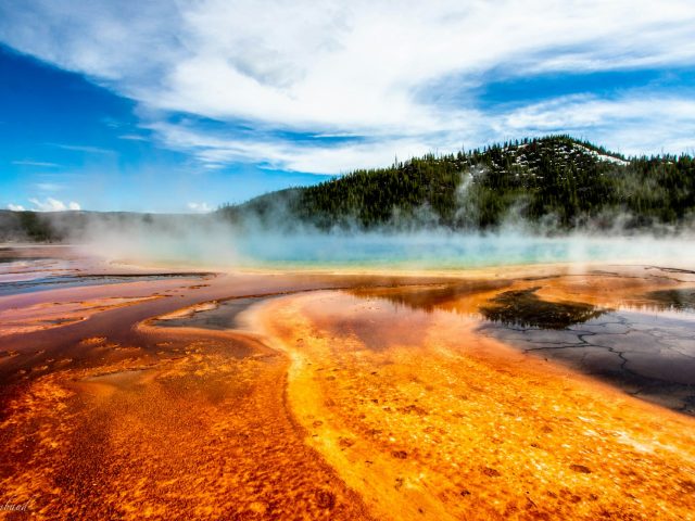 A geyser erupting in a mountain landscape
